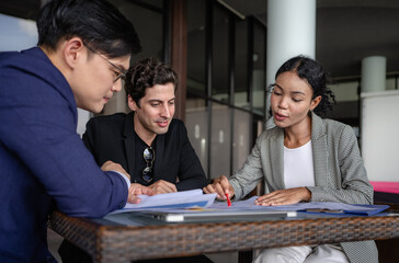 Group of diverse businessperson brainstorming discussing paperwork together. Young multiracial business woman and colleague talking working on startup strategy idea planning. Diversity people teamwork