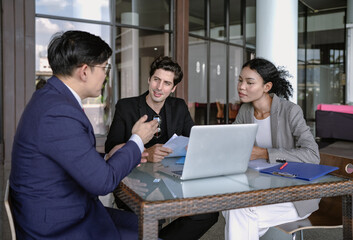 Group of diverse businessperson brainstorming discussing paperwork together. Young multiracial business woman and colleague talking working on startup strategy idea planning. Diversity people teamwork