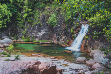 Small Waterfall Cascading from Green Rocks