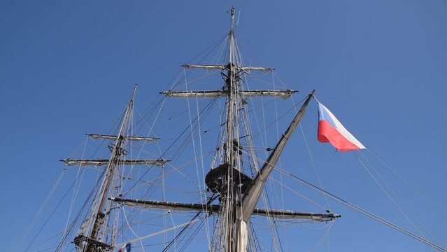 Masts of the brig and flag of France swinging in the wind