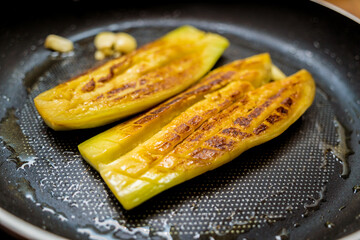 Delicious grilled eggplants with garlic on the fried pan