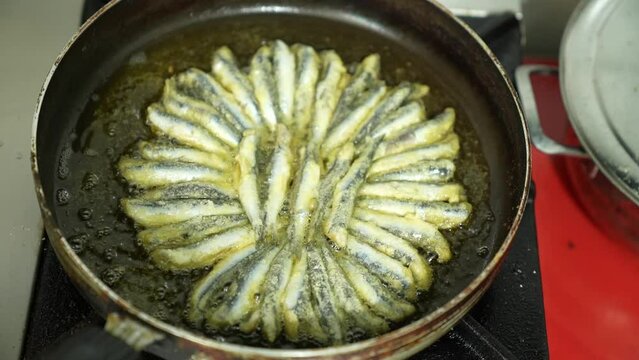 frying fresh fish in a pan, top angle shot