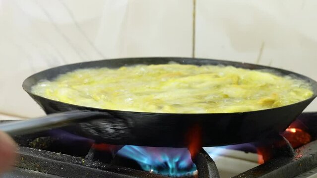 fish frying in oil in a pan, close-up 