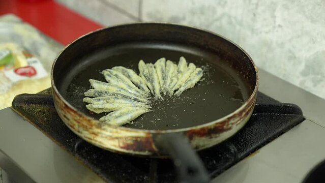 the cook lines the fish in a pan for frying