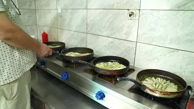 rows of fish frying pans in the kitchen 