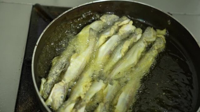 frying fresh fish in a pan, top angle shot