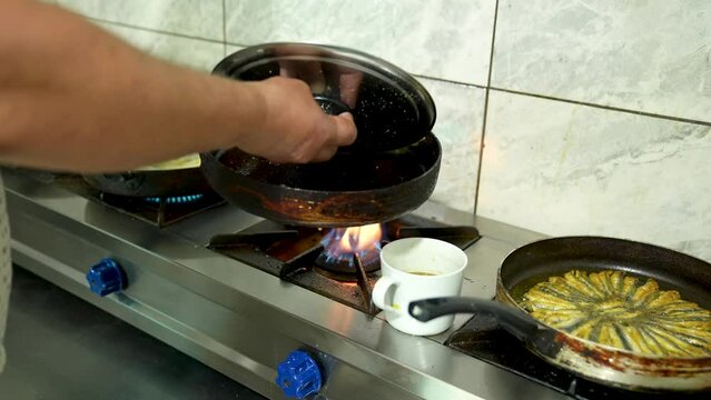 frying the fish in the pan and turning it to cook the other side