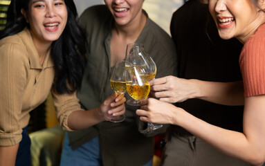 Close up hand holding glass. Group of young asian people smiling friends drinking at birthday party toast with beer. food and beverag