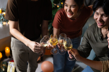 Close up hand holding glass. Group of young asian people smiling friends drinking at birthday party toast with beer. food and beverag