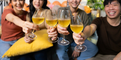 Close up hand holding glass. Group of young asian people smiling friends drinking at birthday party toast with beer. food and beverag