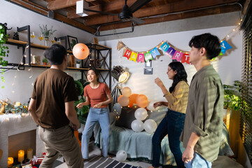Game Race the balloons so they don't fall to the ground. Group of friends smiling enjoying party