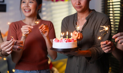 group of friends having fun with sparklers dancing confetti. celebrating Birthday party. Group of friends smiling enjoying party