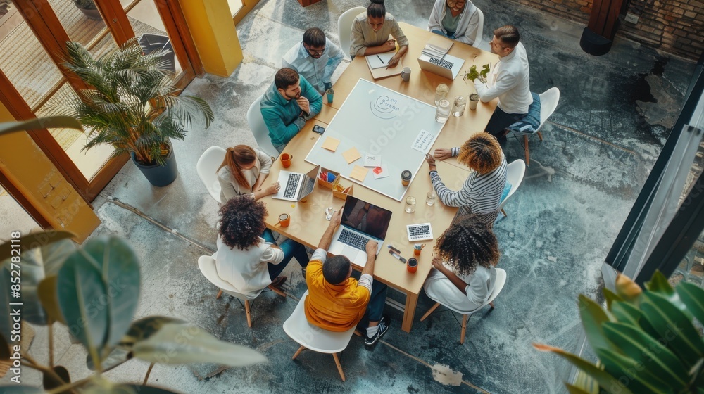 Poster a diverse group of people are gathered around a large wooden table in a modern office setting. they 
