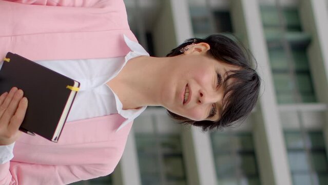 UGC. Woman real estate agent talking to male client against backdrop of modern buildings. Concept of property consultation, urban real estate, and professional communication. User generated content.