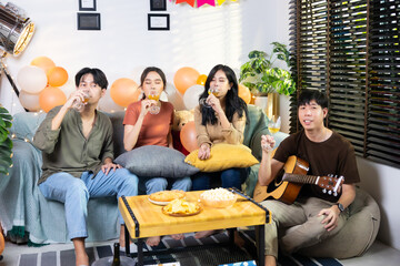Group of young asian people smiling friends drinking at birthday party toast with beer. food and beverag