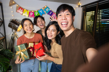 Selfie photo. Happy smile diverse friends enjoying time together and making selfie photo by mobile phone at home party. Group of asian people friends in birthday party at home