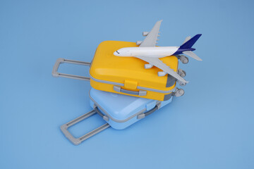 Airplane model on orange and blue suitcases on blue background. Vacation trip concept.
