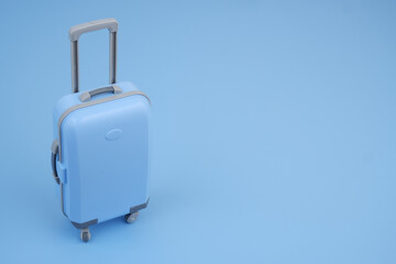 Blue suitcase on blue background. Room for text. Vacation concept.