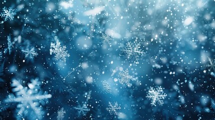 A close-up image of falling snowflakes against a blurred blue background. The snowflakes are in focus and appear to be falling gently, creating a sense of peace and tranquility. The image is perfect f