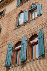 Fassade eines mittelalterlichen Hauses mit grünen Fensterläden in der Altstadt von Verona in Italien