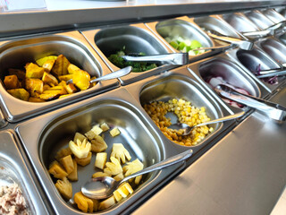 Buffet table stocked with an array of salads and veggies