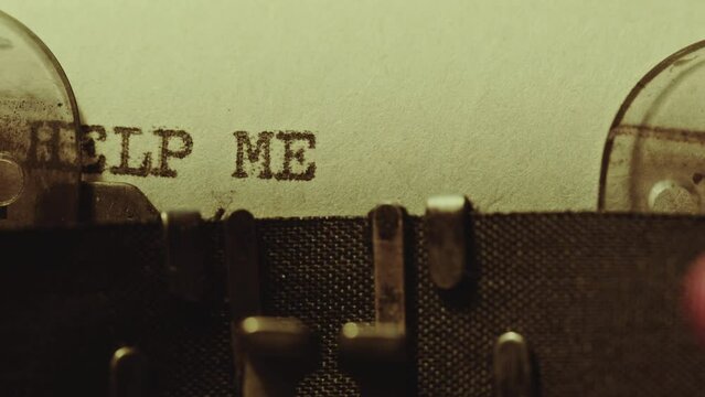 Typing Help Me phrase in capital letters with three exclamation points on paper with analog typewriter. Extreme close-up shot