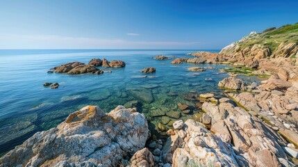Tranquil rocky coast beneath a cloudless blue sky