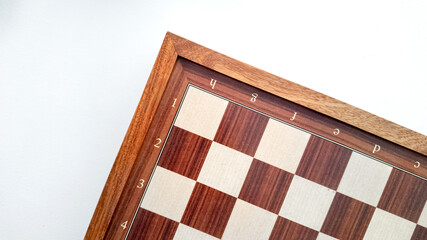 Fototapeta premium Empty wooden chessboard with coordinates isolated on a white background, concept related to strategy games, chess tournaments, and International Chess Day