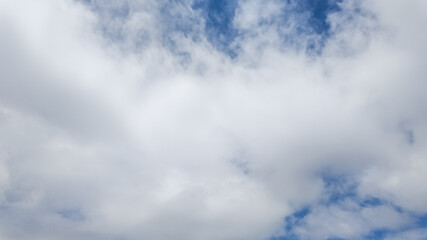 Obraz premium Serene blue sky with fluffy white clouds, ideal for weather-related concepts, outdoor activities promotion, and Earth Day backgrounds