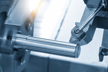 The  CNC lathe machine forming  cutting the metal shaft parts in the light blue scene with lighting effect.