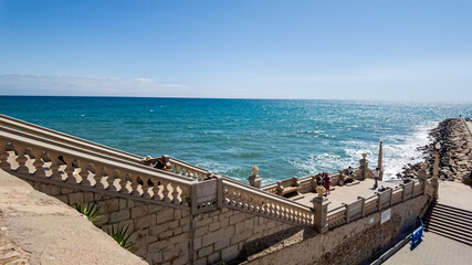 Obraz premium Sunny seaside promenade with decorative balustrade overlooking the turquoise ocean, ideal for vacation and summer travel themes Related concepts: travel, summer vacations