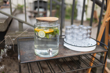 A jar of lemon and mint water for drinking in a restaurant on a table outside.