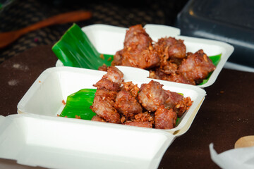 Two containers of meat with a green leaf on top