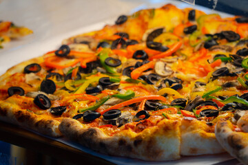 A pizza with a variety of vegetables including olives, peppers, and mushrooms