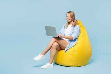 Full body young happy woman she wears white top shirt casual clothes sit in bag chair hold use work...