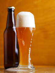 Foamy unfiltered wheat beer on a wooden table.