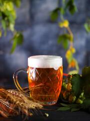 Beer mug on the table with green hops