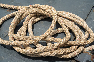 Fototapeta premium Nautical vessel heavy rope or mooring rope. this rope will anchor for stability when the ship is docking at harbour. Transportation equipment object photo, selective focus.