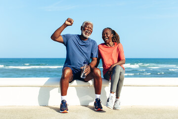 Joyful senior couple laughing on a sunny seaside promenade © (JLco) Julia Amaral