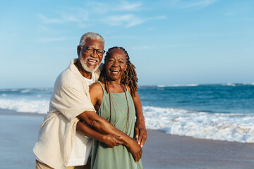Joyful senior couple embracing on a sunny afternoon at the beach