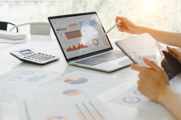 Professional analyzing financial data graphs, charts on laptop display at a modern workspace. Financial analysis or business evaluation concept