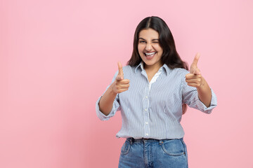 Positive Indian woman showing thumbs up and winking to camera
