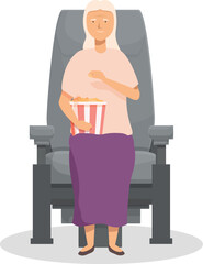 Smiling senior woman sitting in a movie theater and eating popcorn