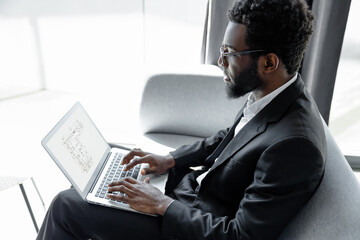 Man wearing official style suit working online on laptop in office