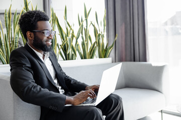Man wearing official style suit working online on laptop in office