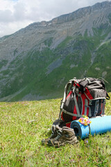 Hiking equipment. hiking gear set - backpack, camping mat, trekking boots in mountains, nature background. Mountains landscape. adventure, unity with wild nature, tourism, travel concept