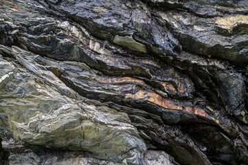 Contrasting black rock with bright yellow mineral inclusions. Ideal for nature, geology and abstract art themes. A shot that showcases the beauty of natural formations.