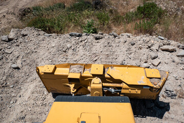 Bulldozer de esteiras com a lamina frontal a terraplanar o solo para a construção de uma estrada