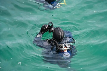 Diver with goggles in hand to clean