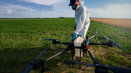 Modern technologies in agriculture. Industrial drone at green field for spraying pesticides to...
